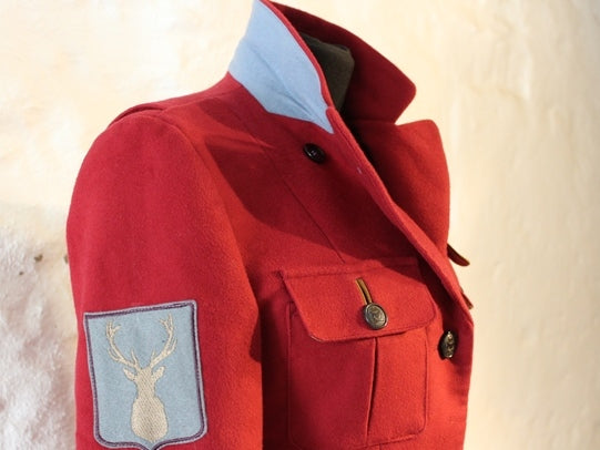 Fieldjacket Damen rot aus Moleskin im Schnitt für Reitsport und Jagd. Ellenbogen Patches in okker. Detail Emblem